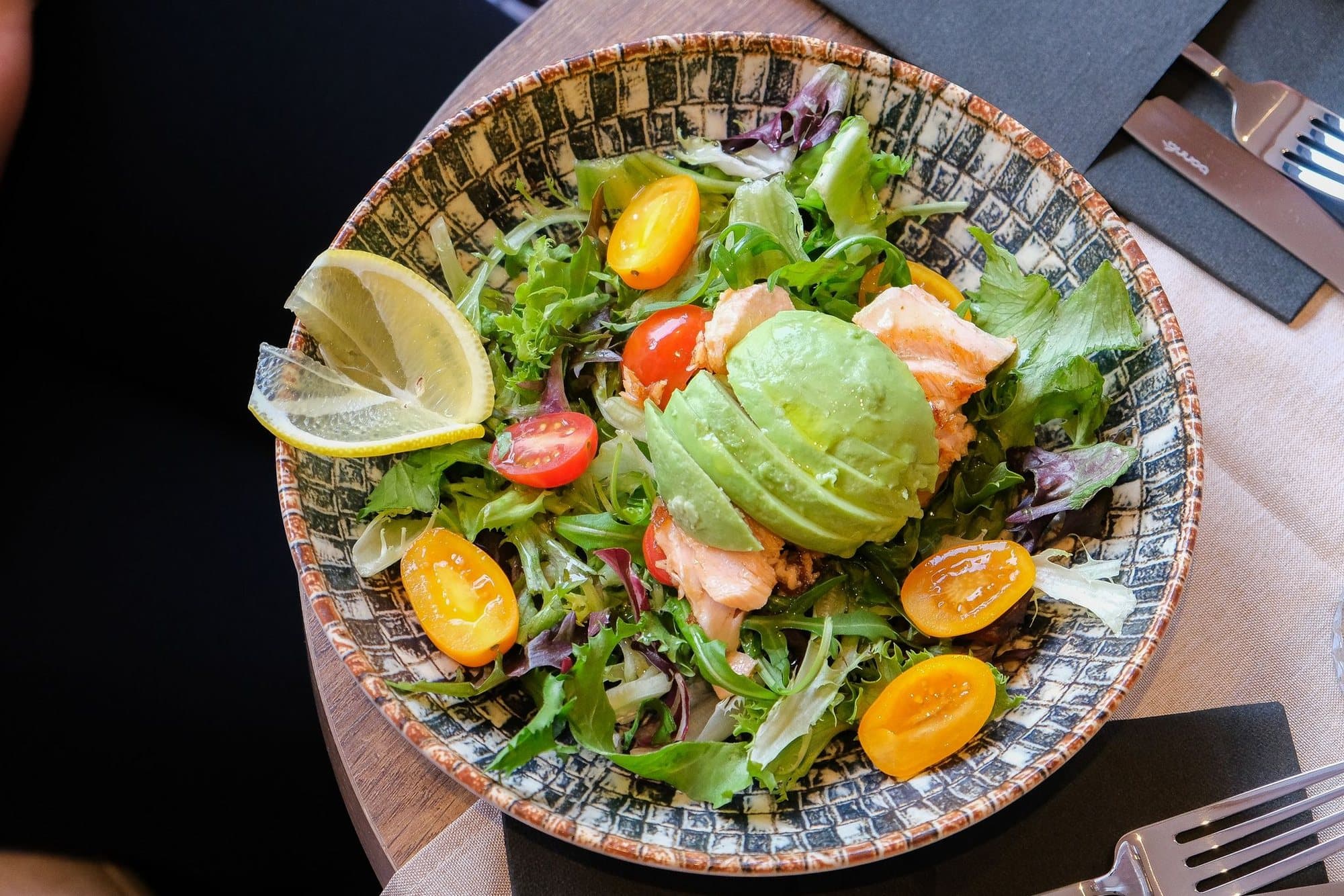 Salmon and avocado salad with baby tomatoes and lemon
